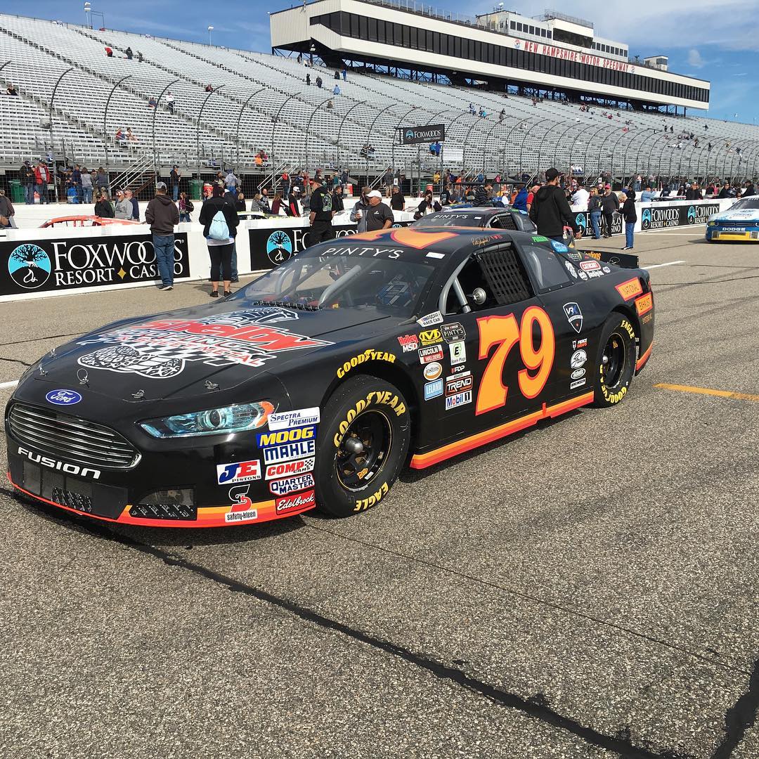 Black and orange wrapped race car on track